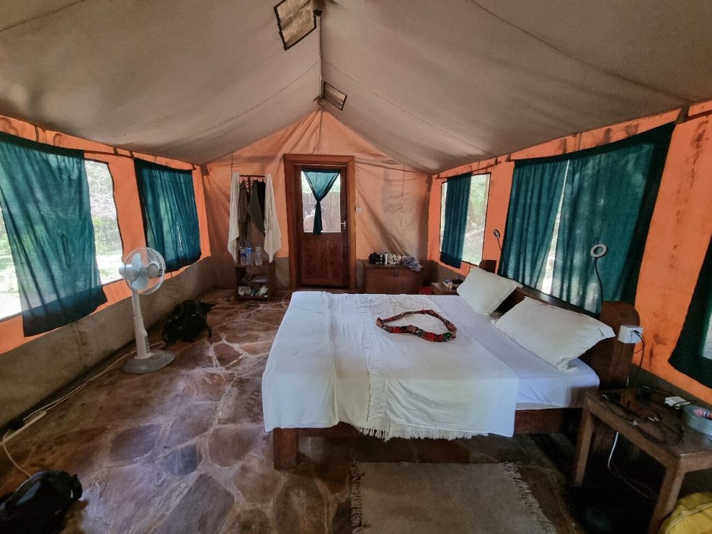 Safari tent interior with a double bed and fan, Udzungwa Mountains National Park