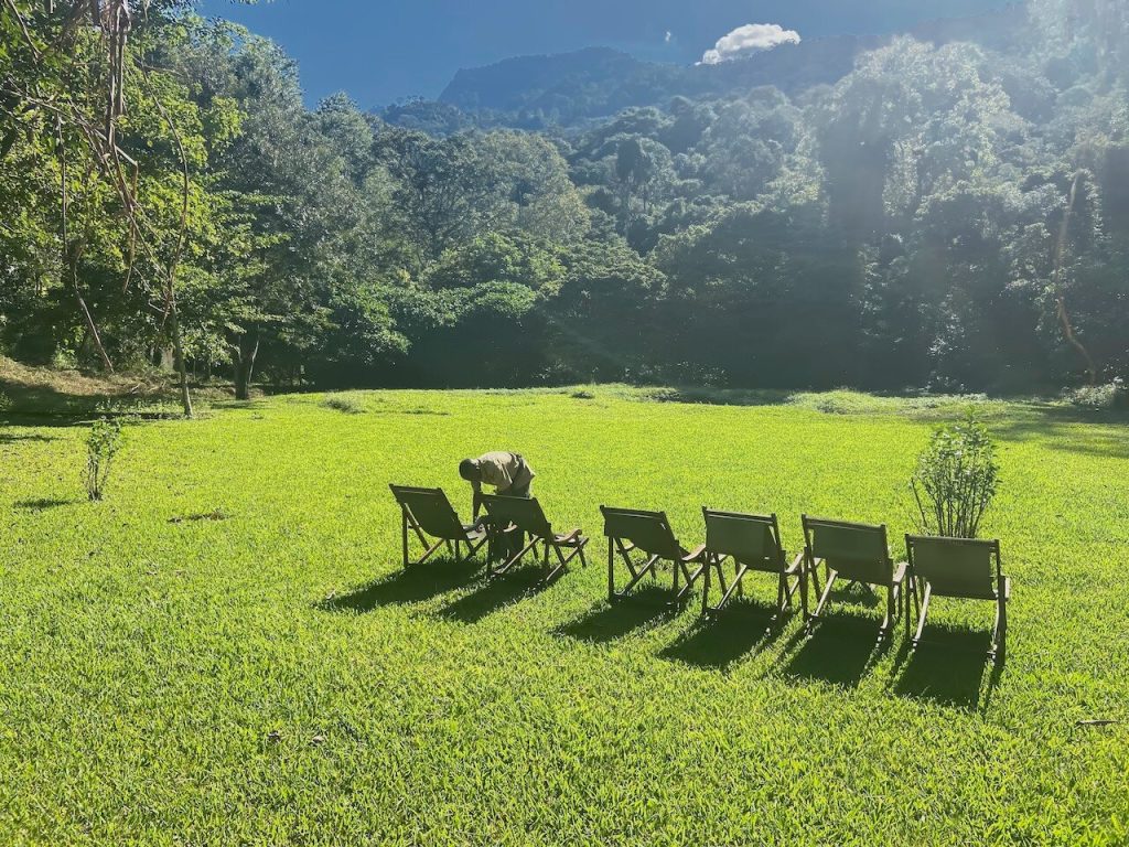Staff arranging six green deck chairs, Udzungwa Mountains National Park