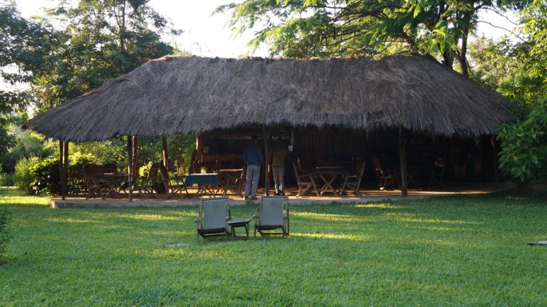 Thatched bar banda and deckchairs on the lawn, Udzungwa Mountains National Park