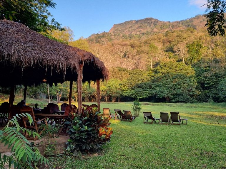 Thatched dining banda and lawn chairs at sunset, Udzungwa Mountains National Park