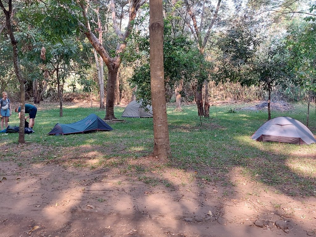 Three dome tents and two campers packing up under the trees, Udzungwa Mountains National Park