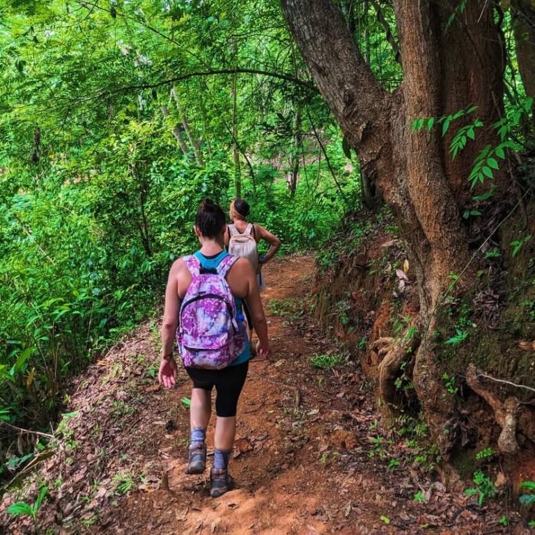 Two women hiking a red dirt forest trail, Udzungwa Mountains National Park